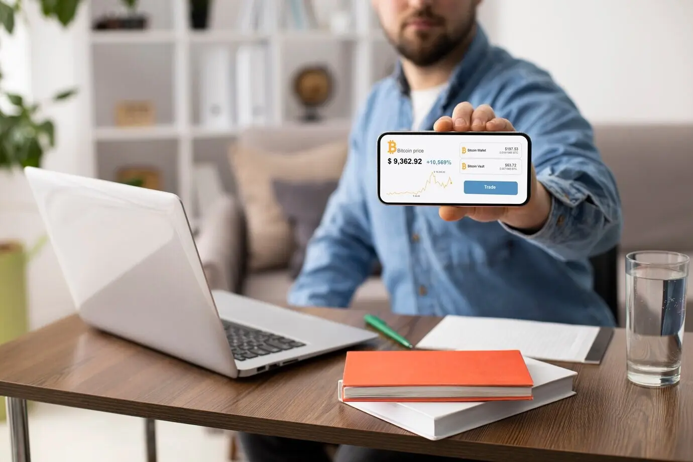 Мужчина держит смартфон в помещении.